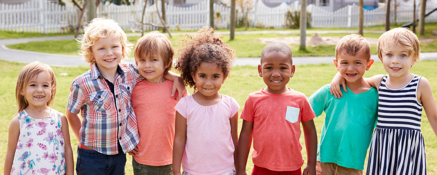 Group of children with arms around each other.